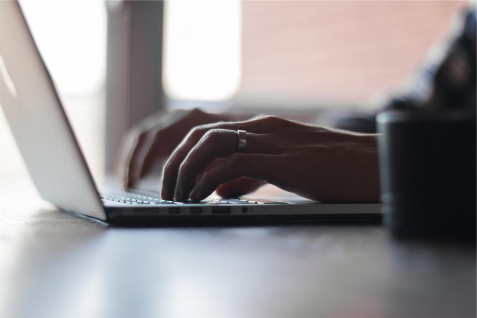 Hands typing on a keyboard in an office setting